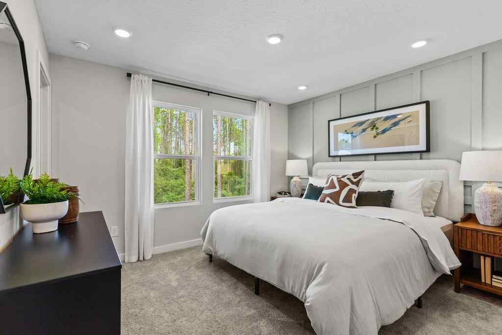 A bedroom with a bed and a table.