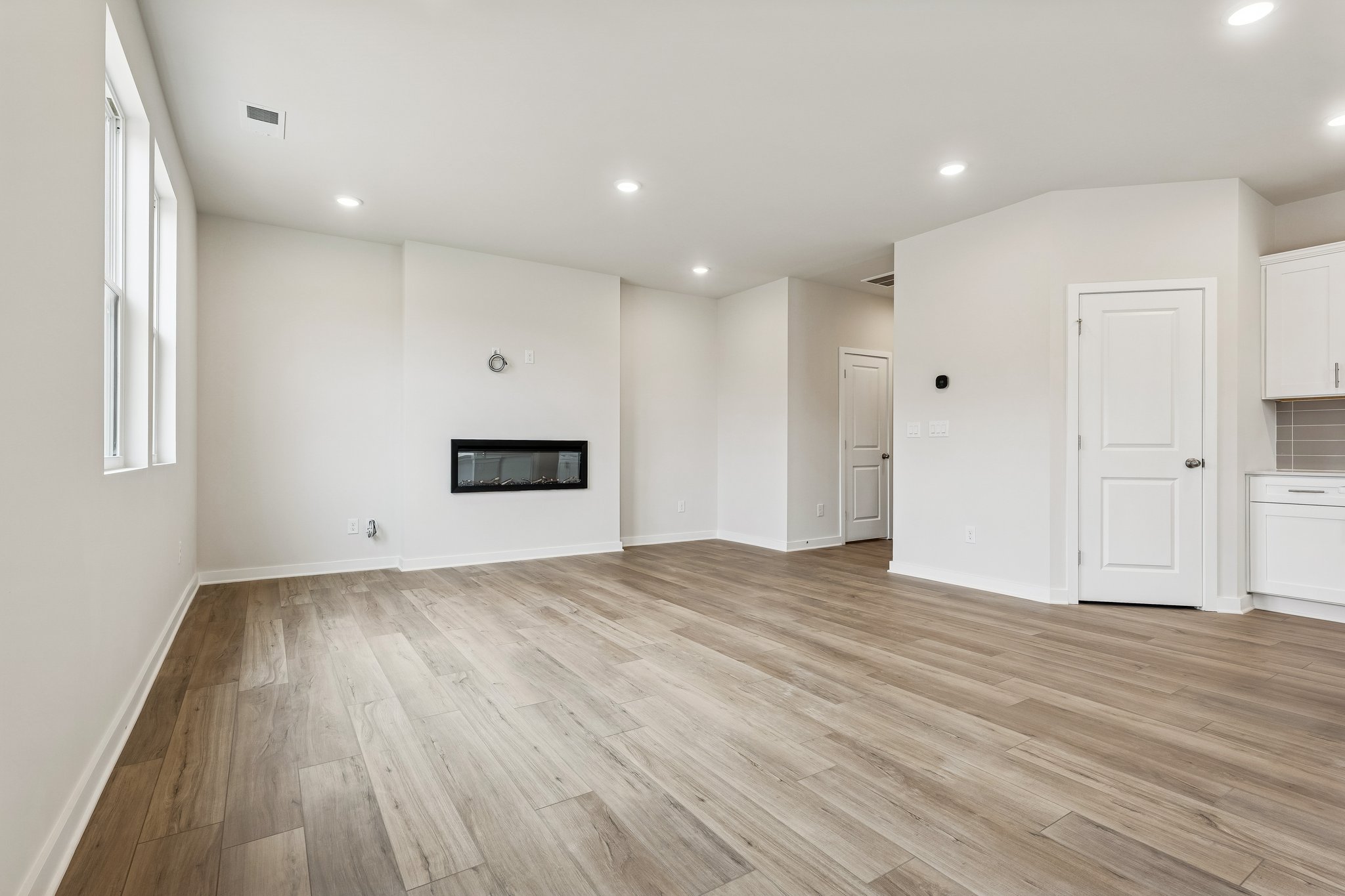 A room with a wood floor and white walls.