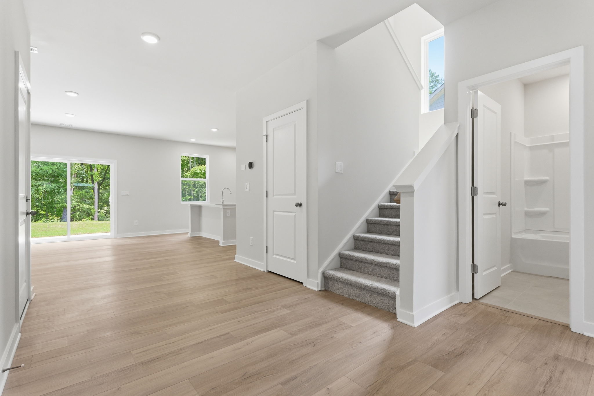 A room with white doors and wood floors.