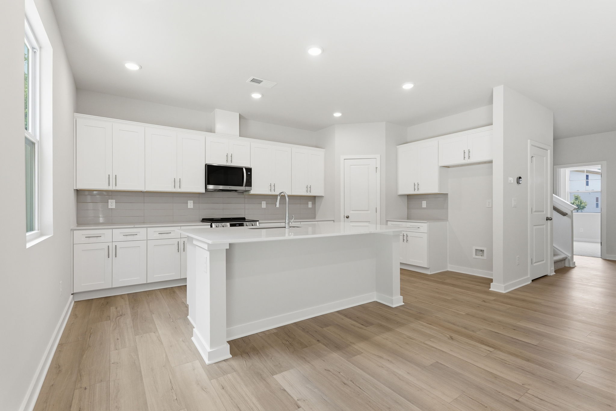 A kitchen with white cabinets.