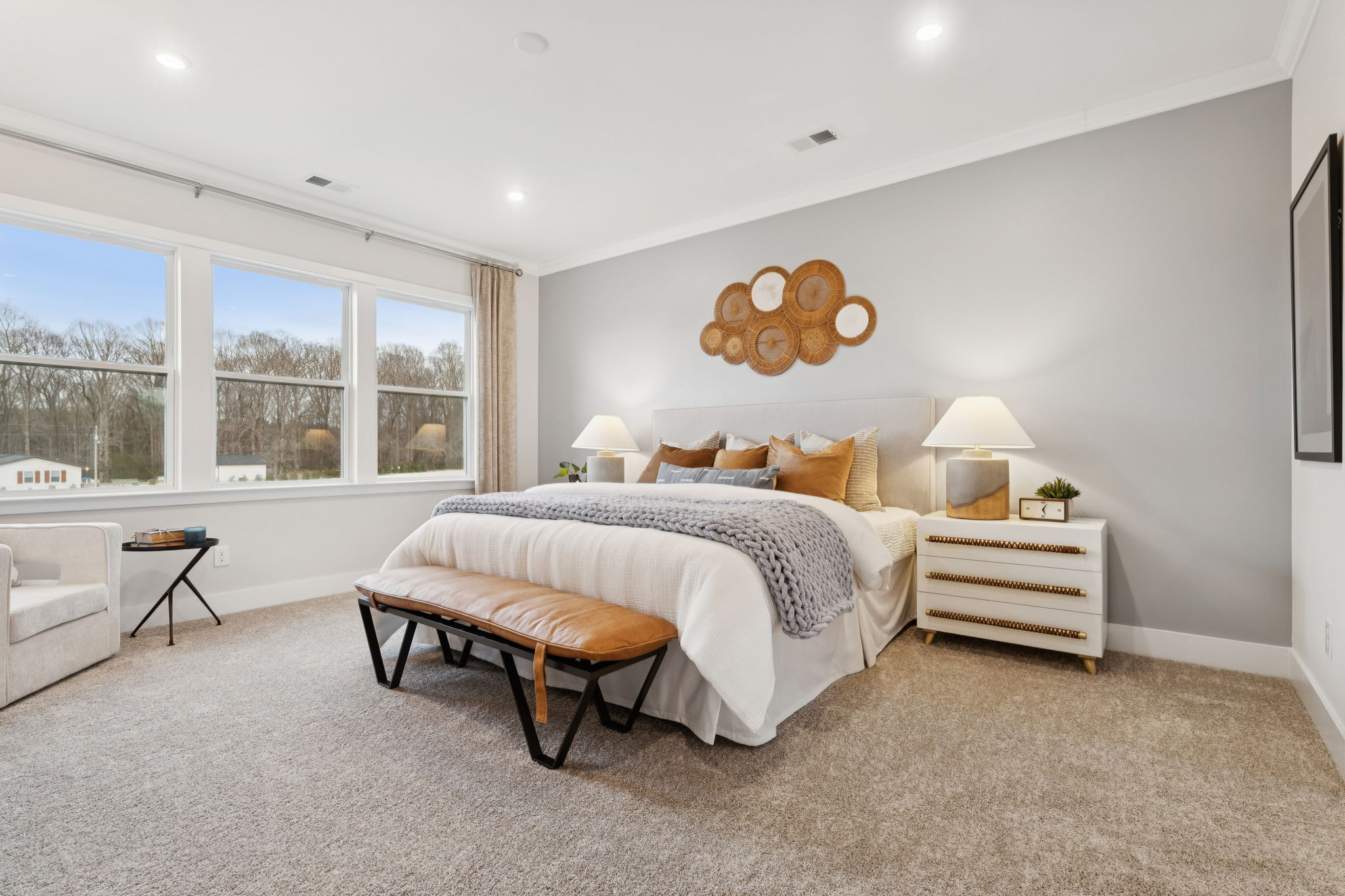 A bedroom with a bed and a bench.