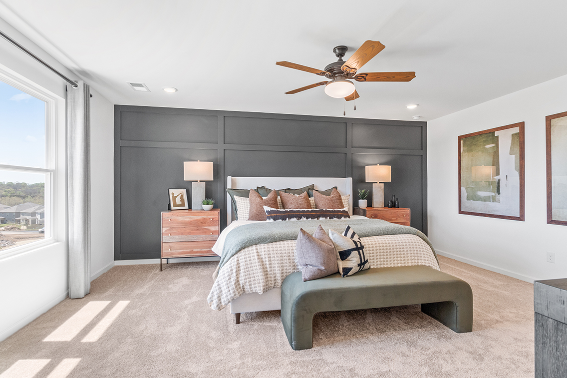A bedroom with a bed and a fan.
