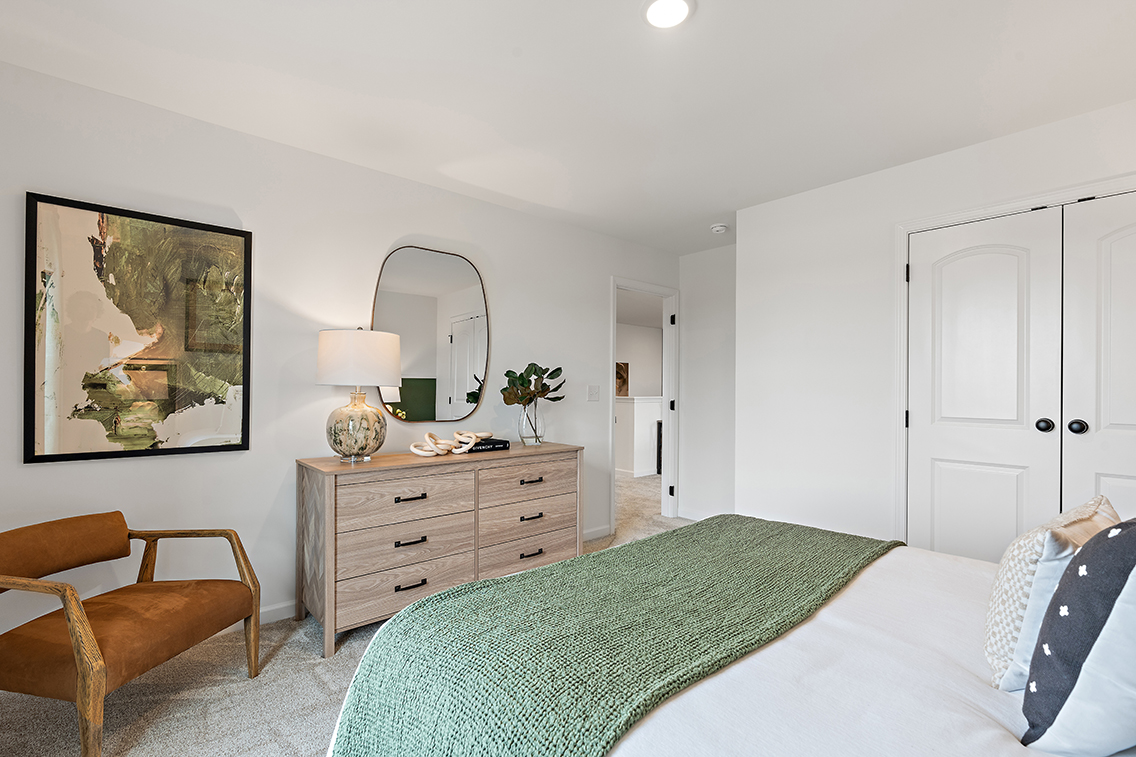 A bedroom with a bed and a mirror.