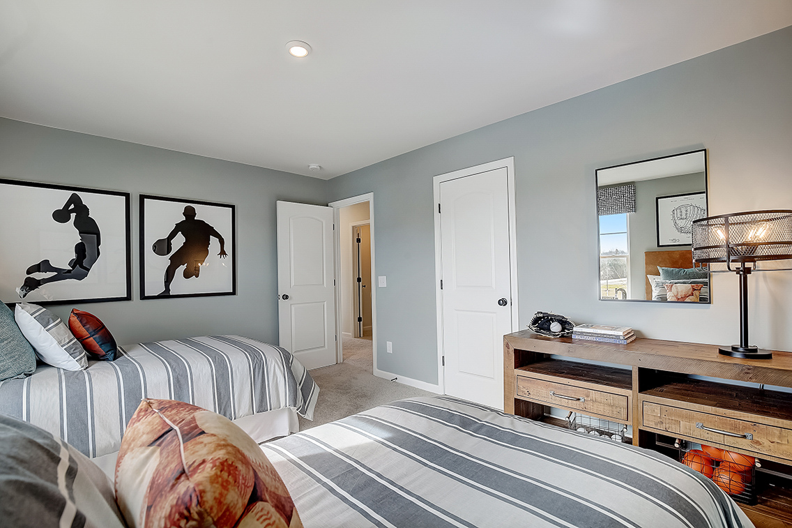 A bedroom with a bed and a desk.