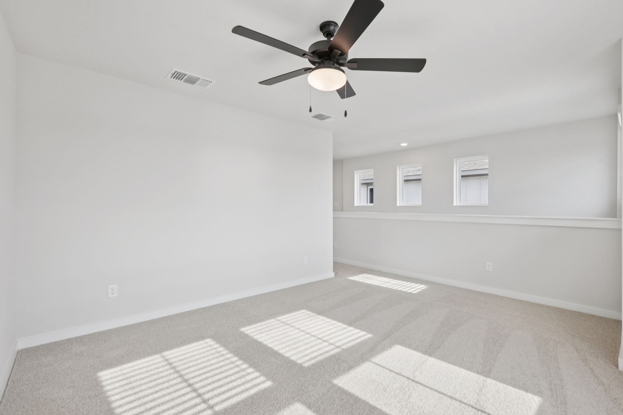 A room with a ceiling fan and a tile floor.