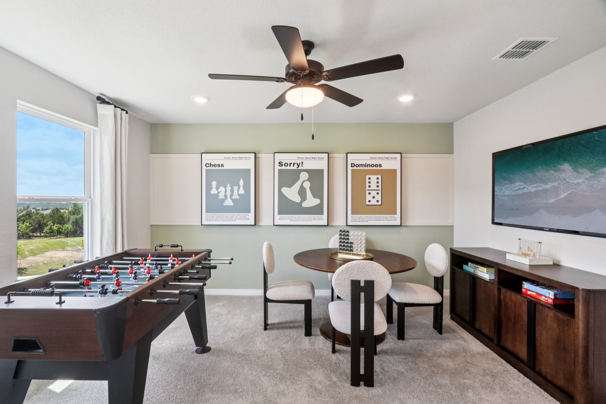 A room with a pool table and chairs and a large fan.