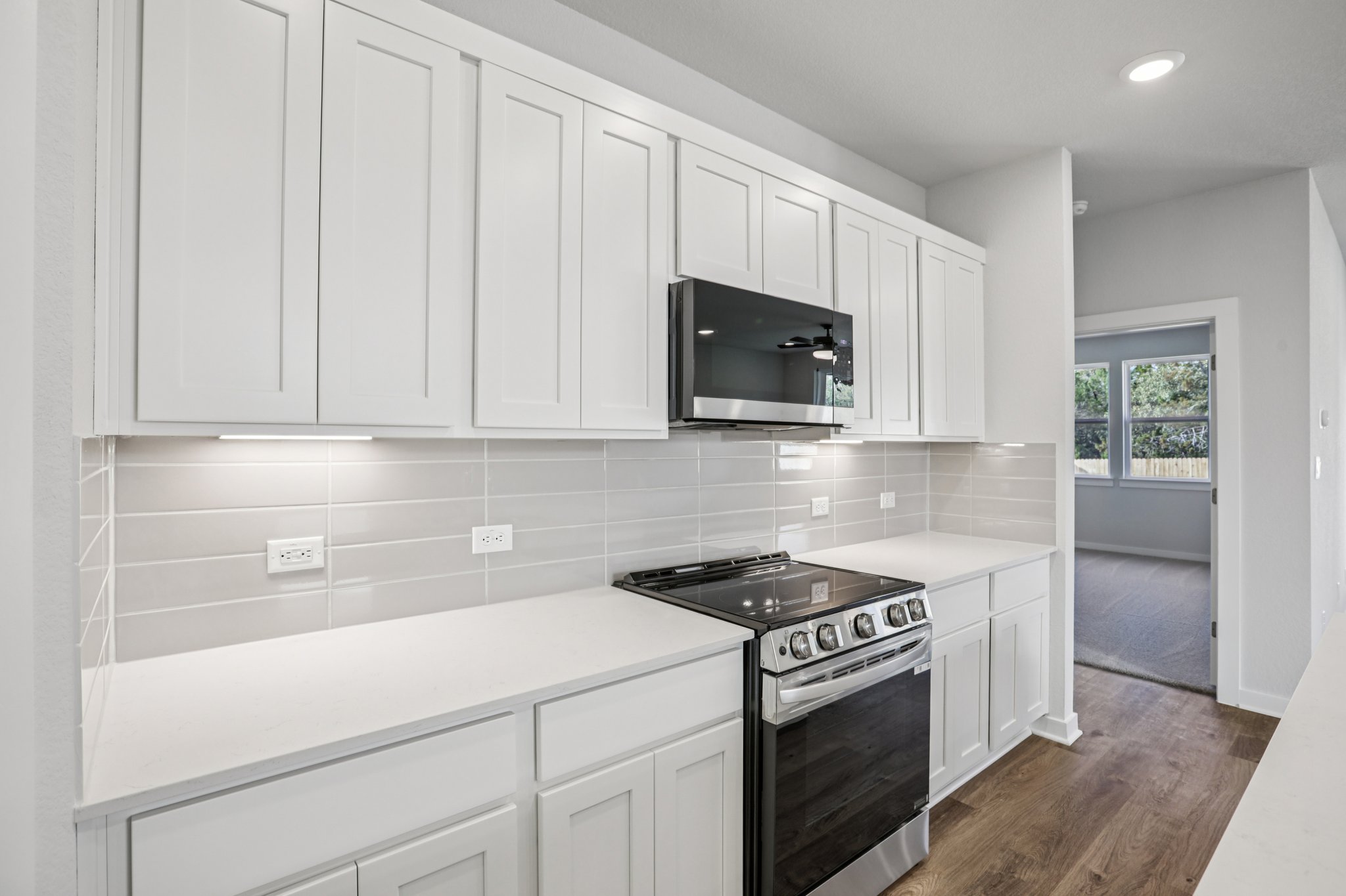 A kitchen with white cabinets.