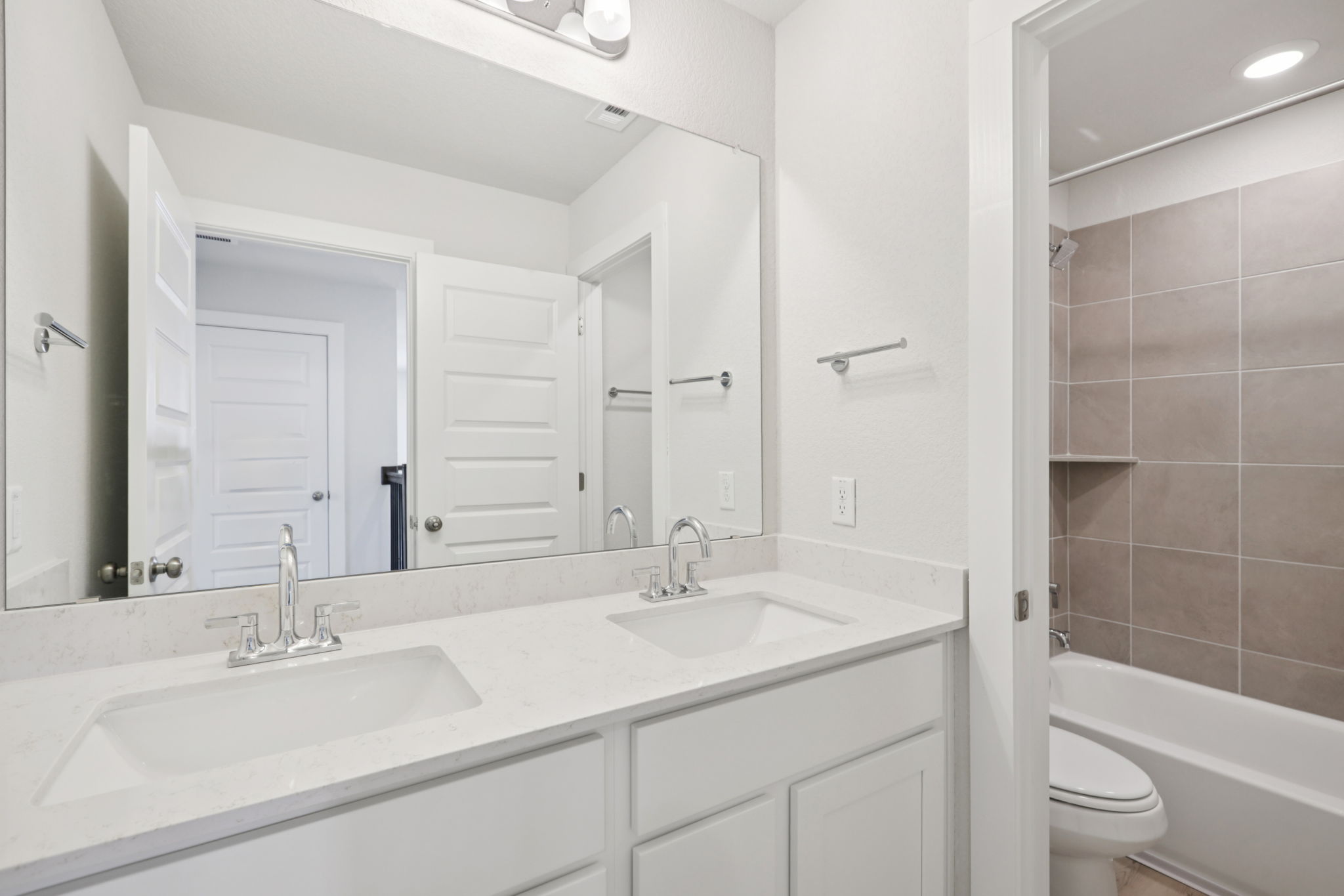 A bathroom with a large mirror.