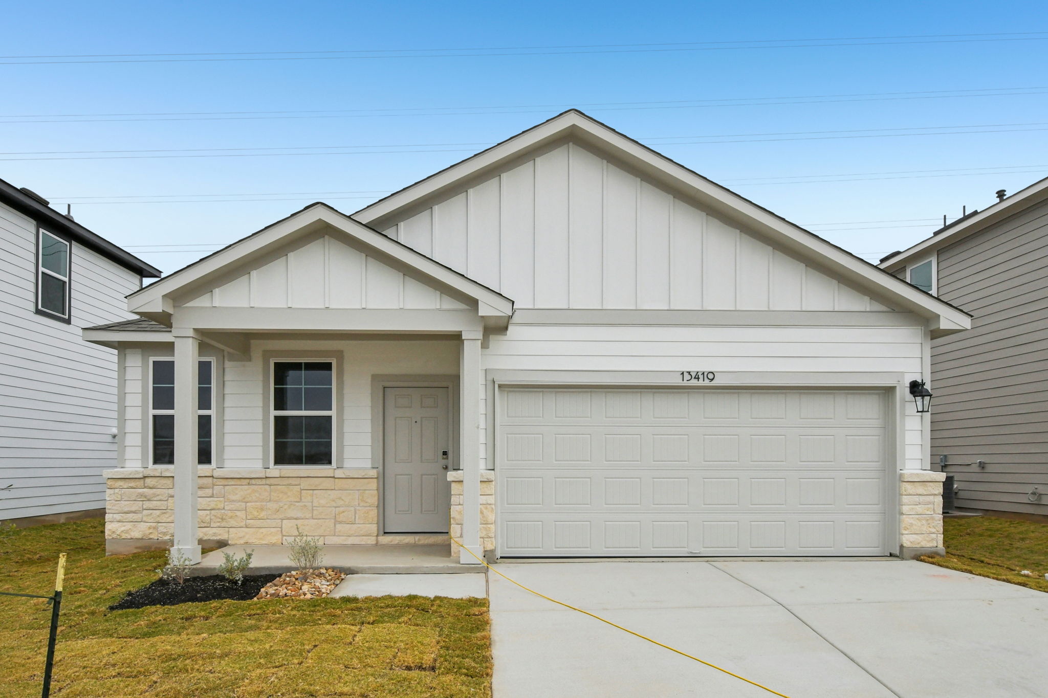 A white garage with a garage with American Gothic House in the background.