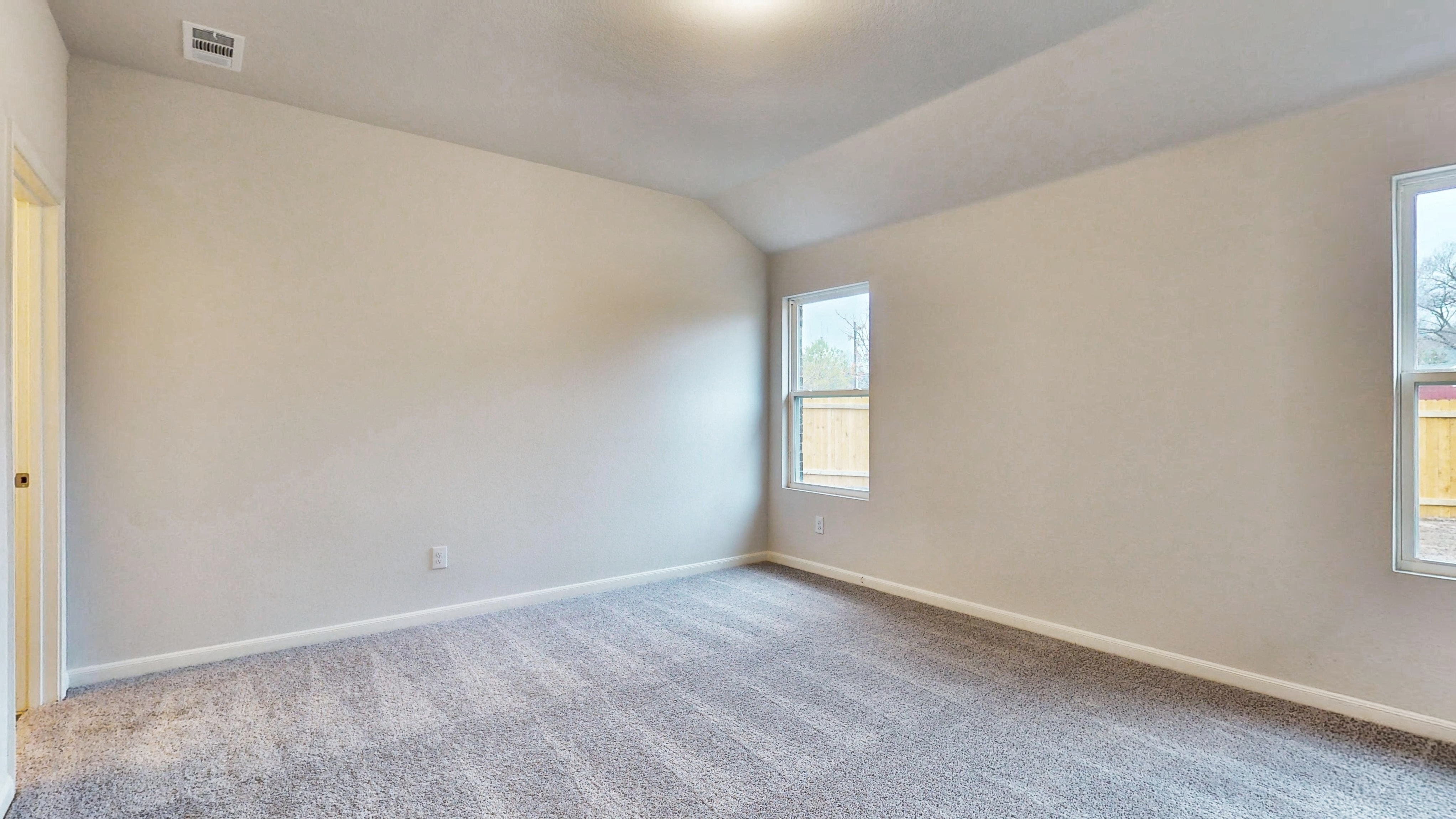 A room with a carpet and windows.