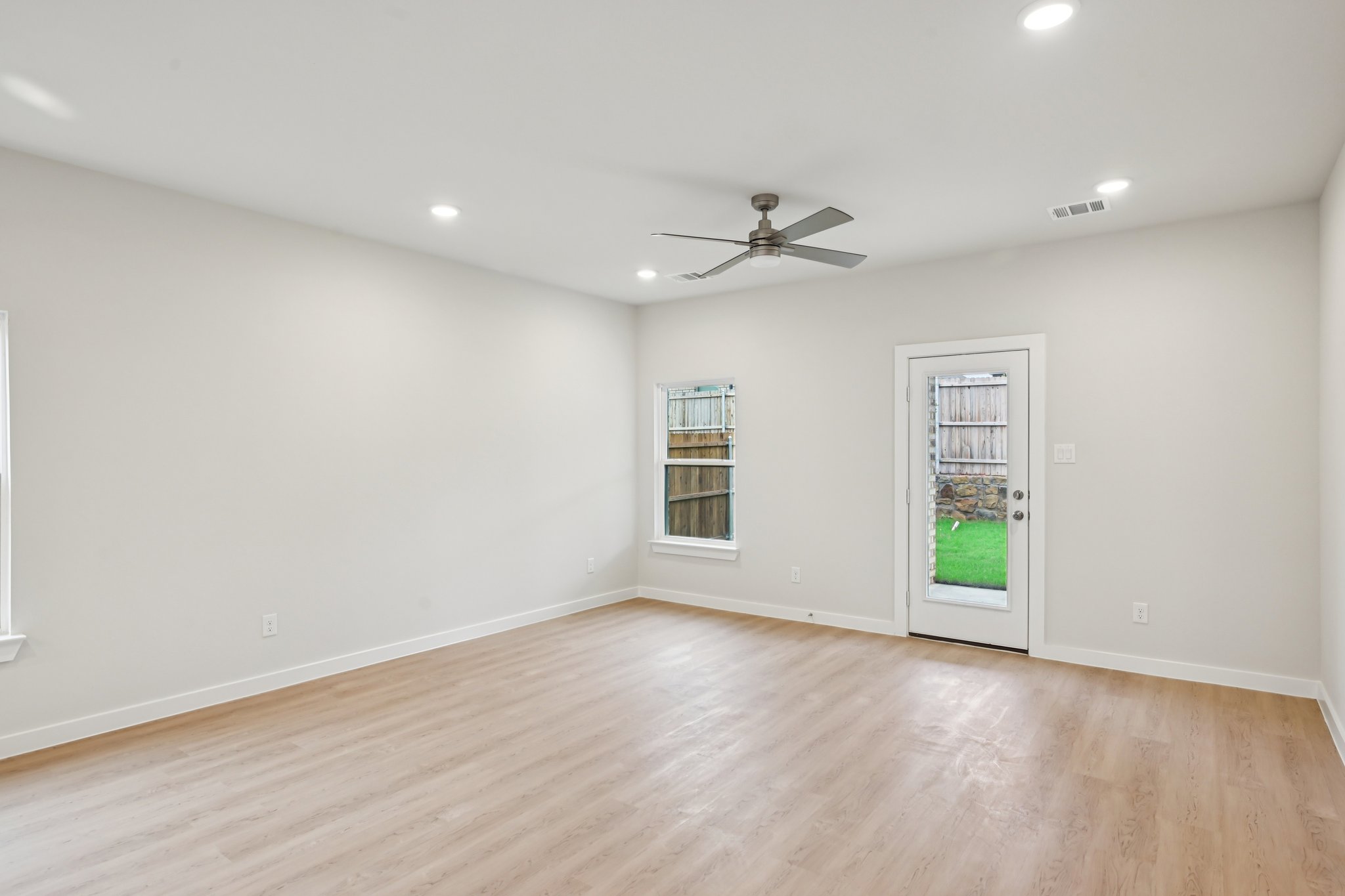 A room with a wood floor and a ceiling fan.