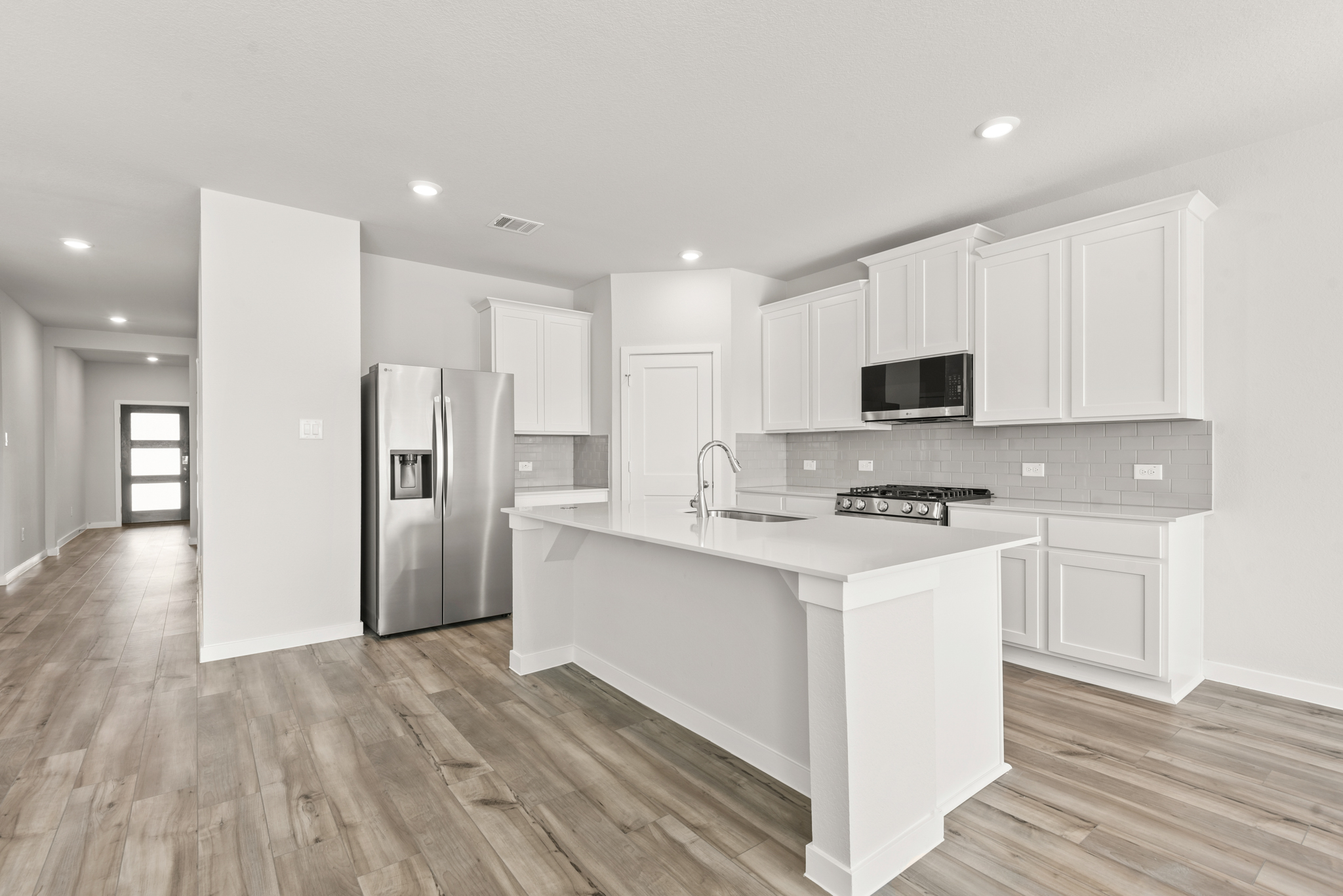 A kitchen with white cabinets.