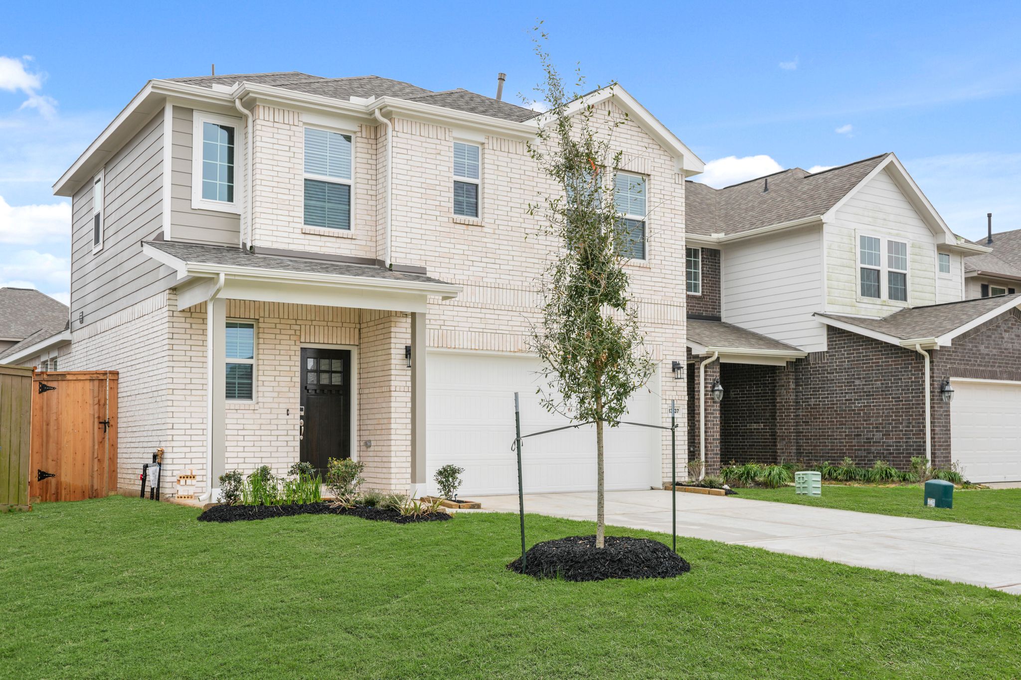 A large house with a tree in the front yard.