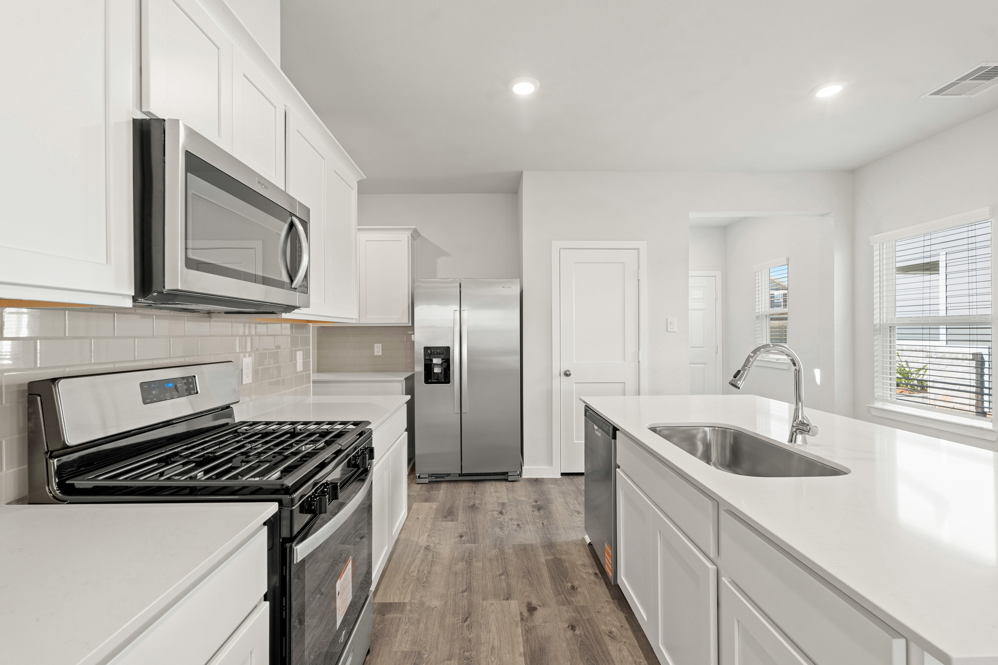 A kitchen with white cabinets.
