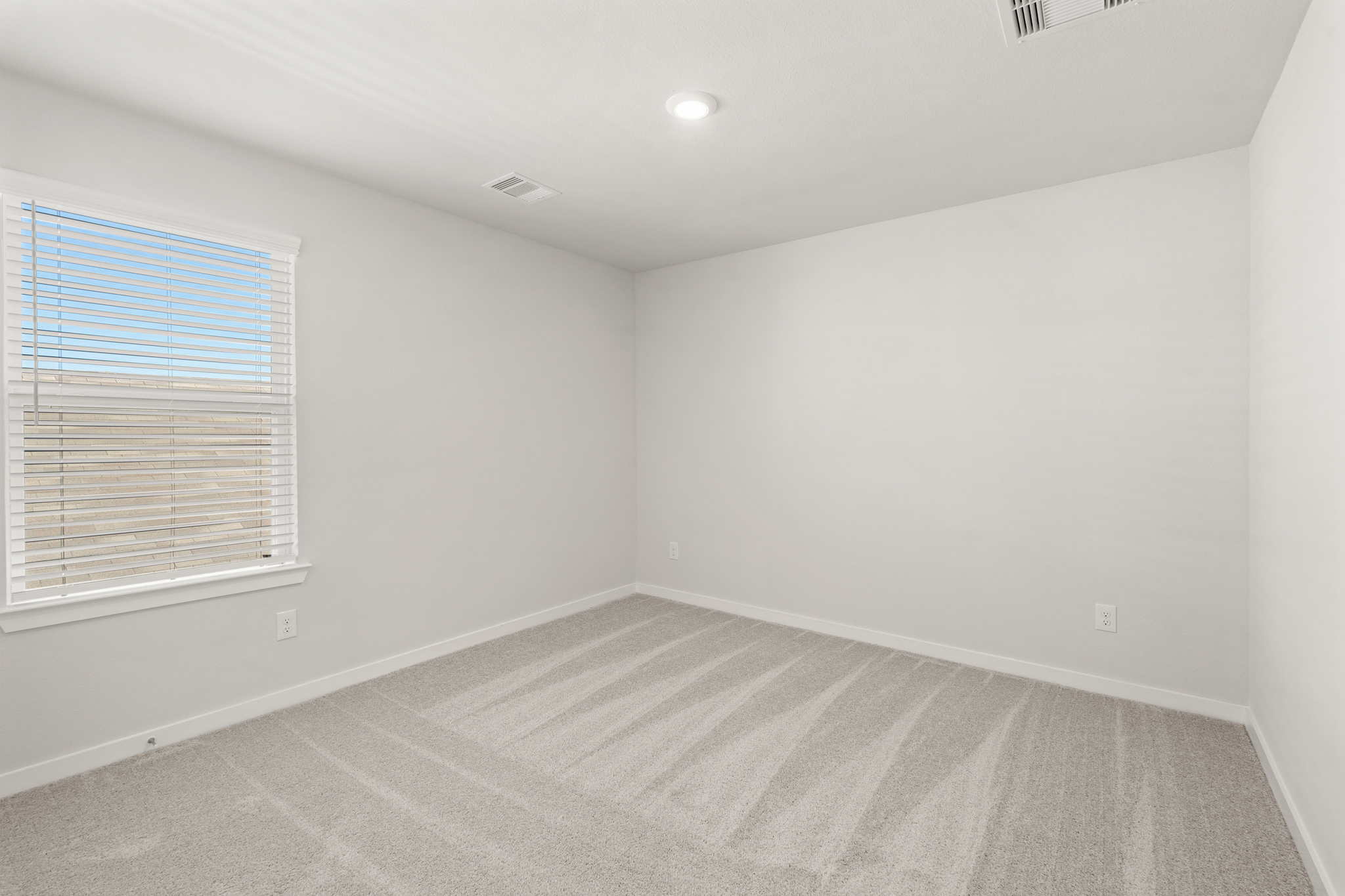 A room with a carpet and a window.