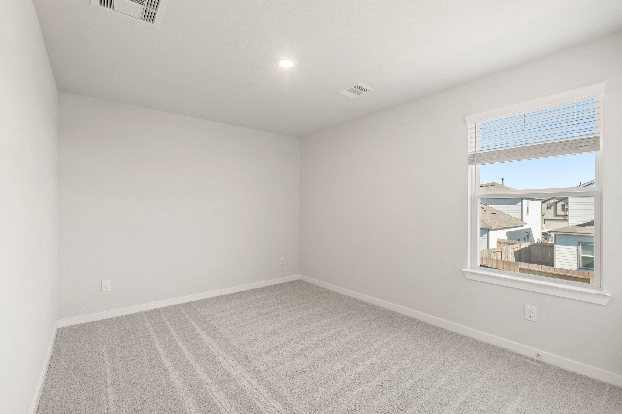 A room with a window and a rug.