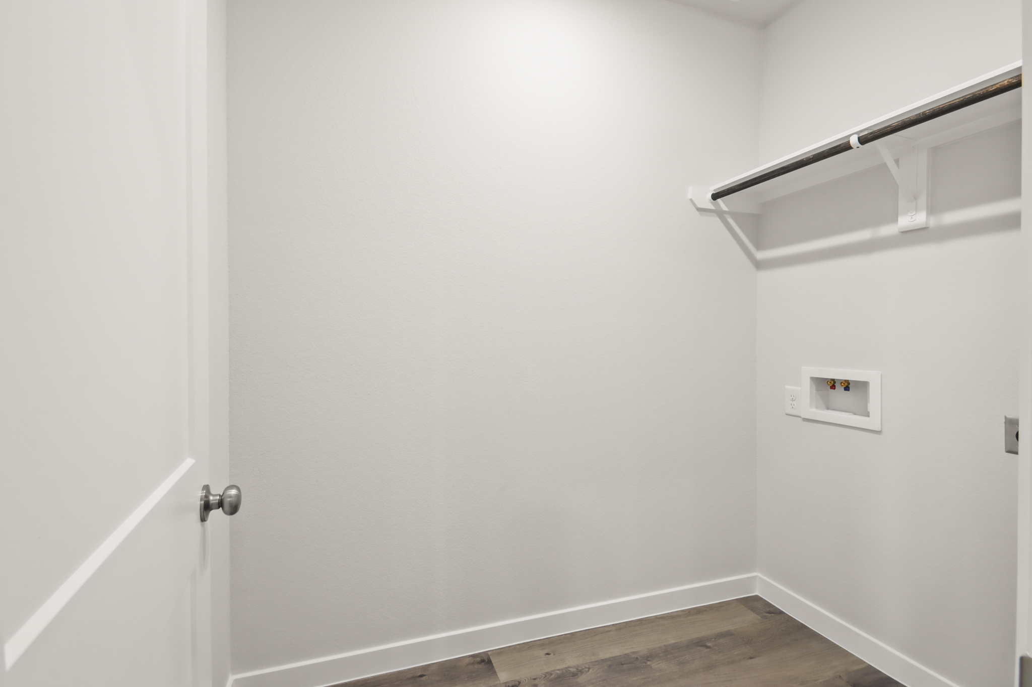 A white door with a metal bar.