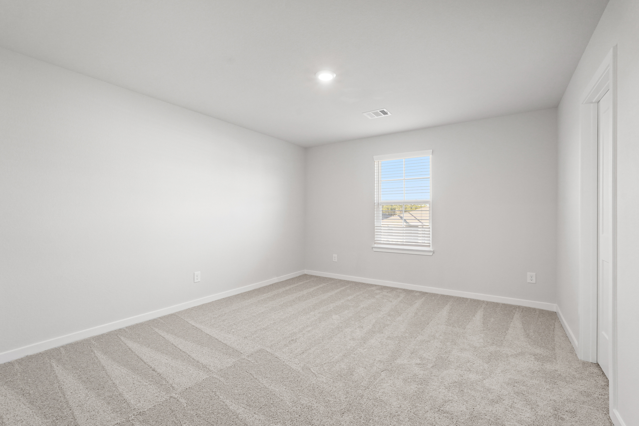 A room with a carpet and a window.