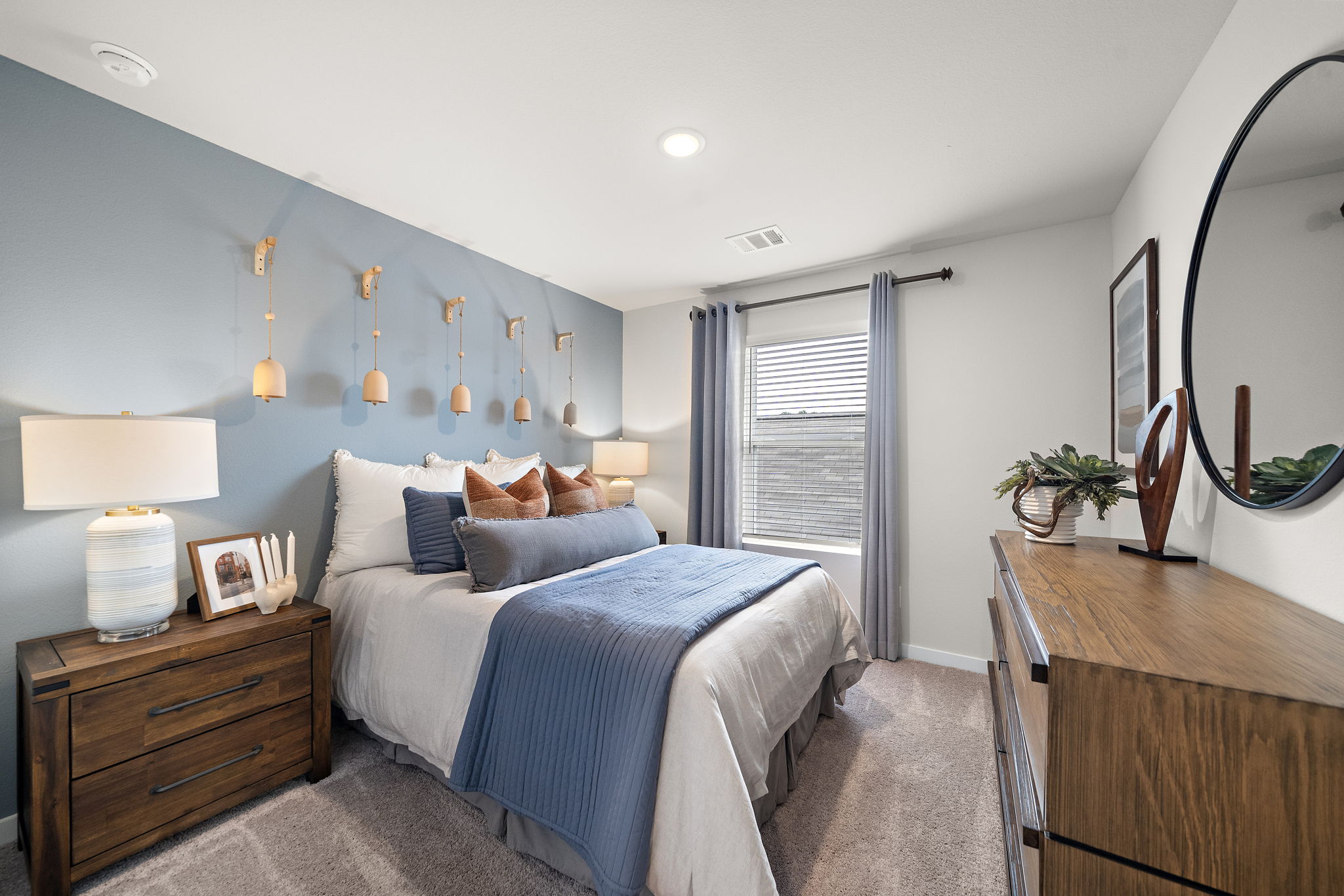 A bedroom with a bed and a mirror.