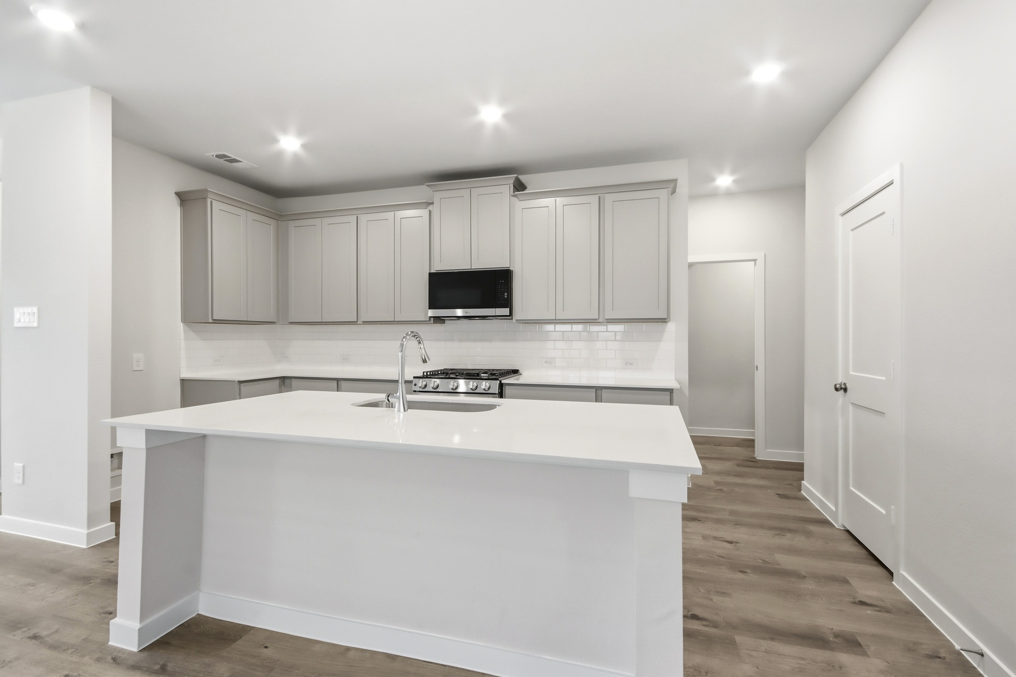 A kitchen with white cabinets.