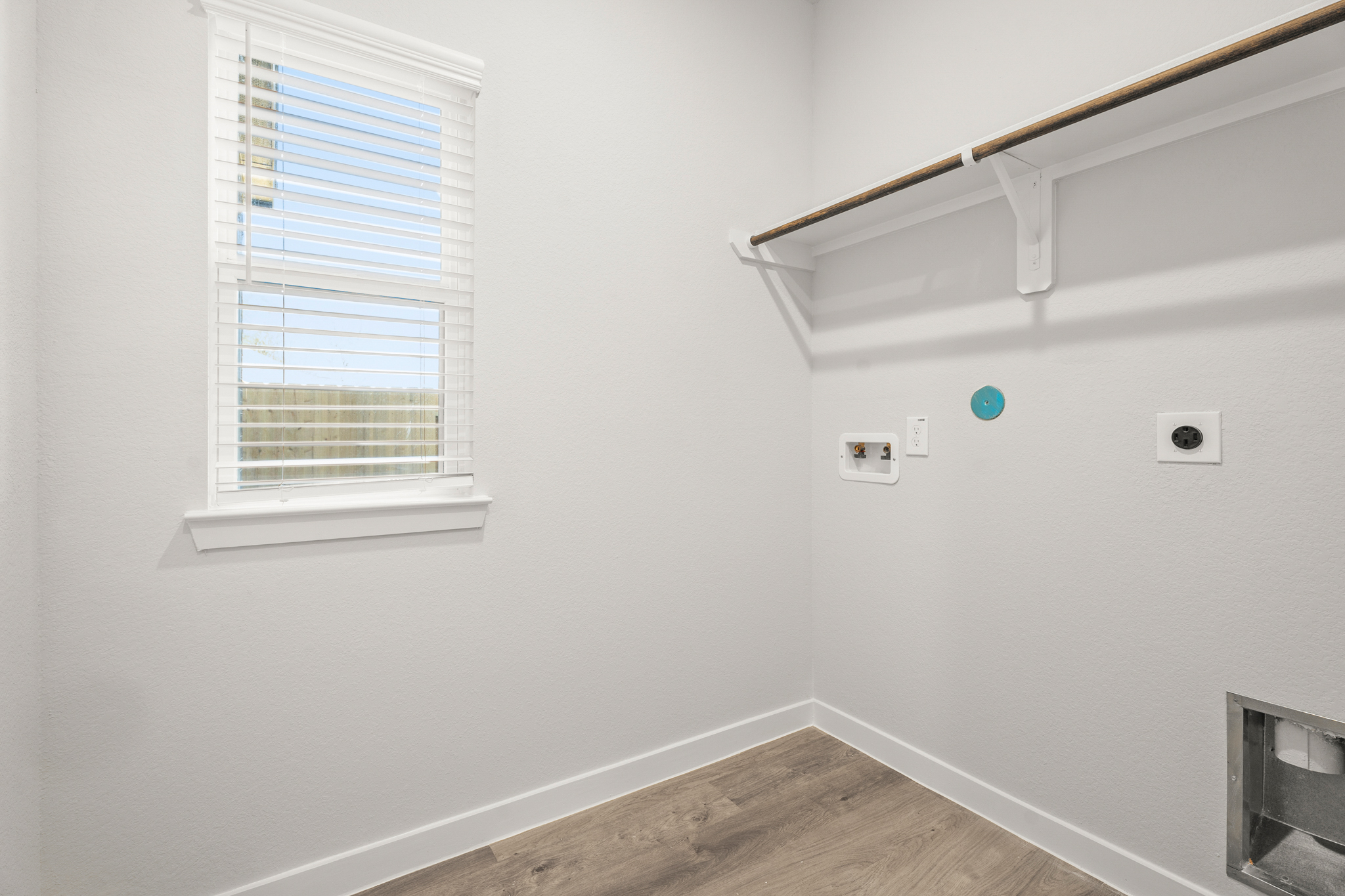 A room with a window and a wood floor.