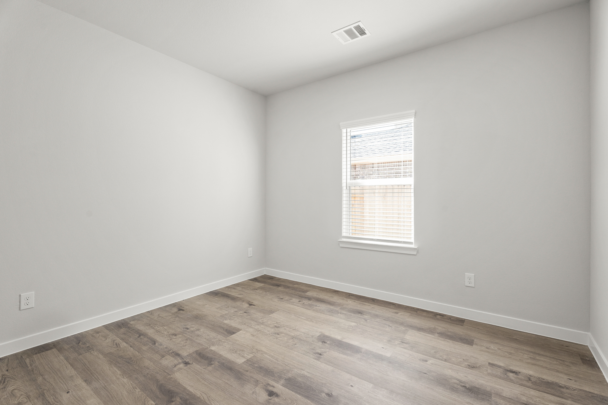 A room with a wood floor and a window.