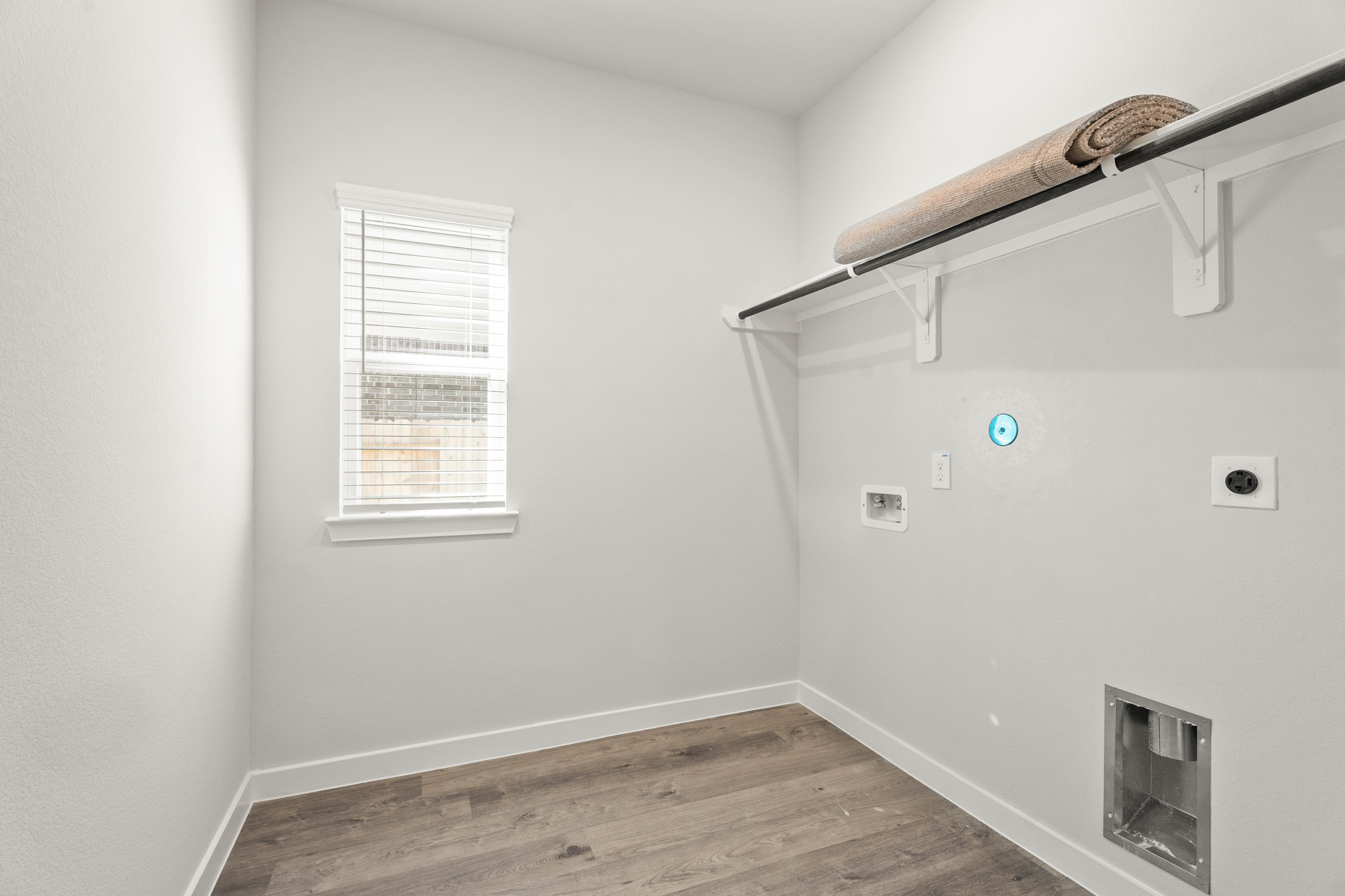 A room with a wood floor and a vent.