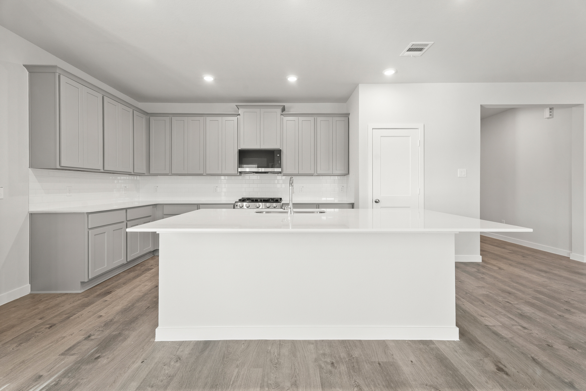 A kitchen with white cabinets.