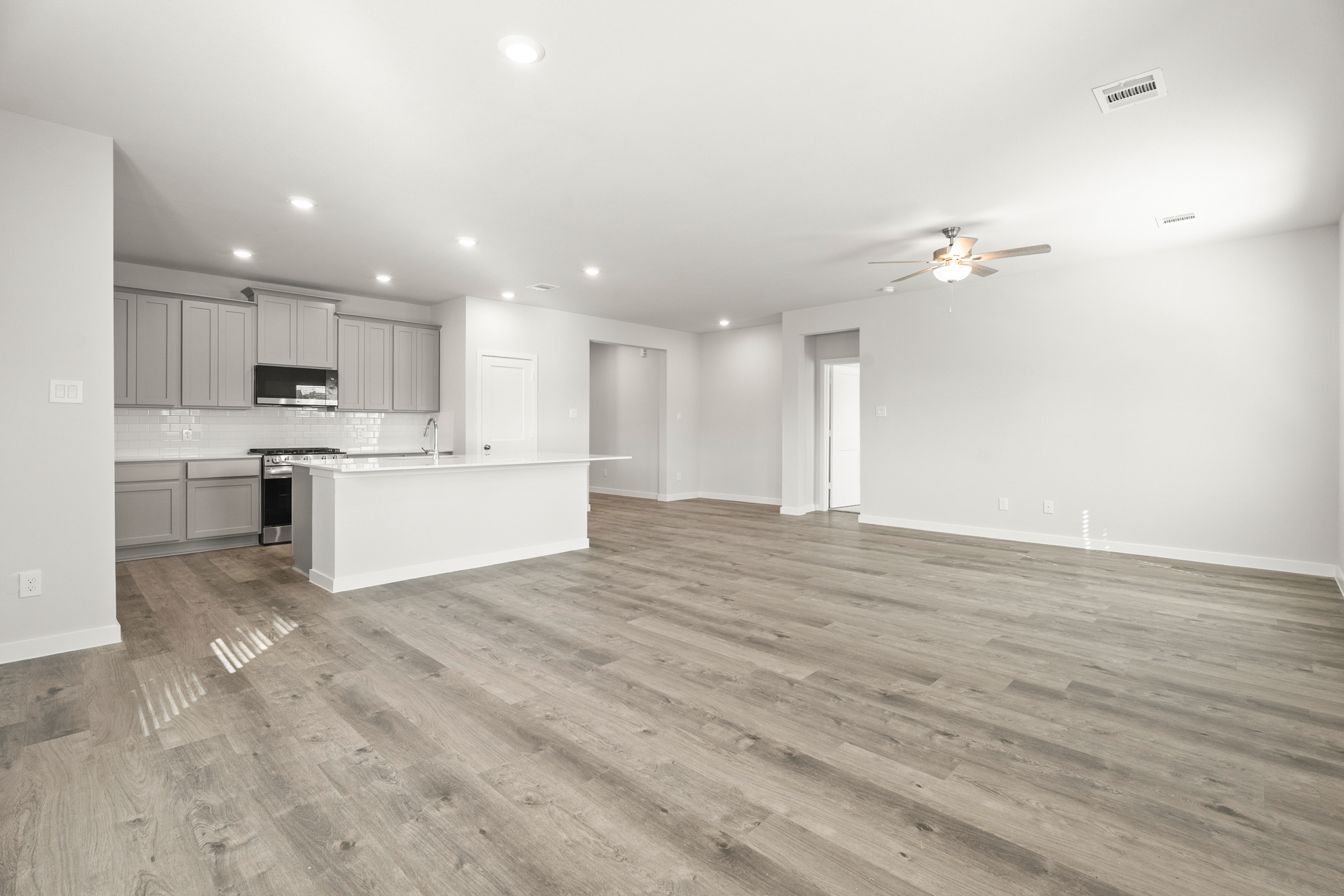 A large kitchen with a wood floor.