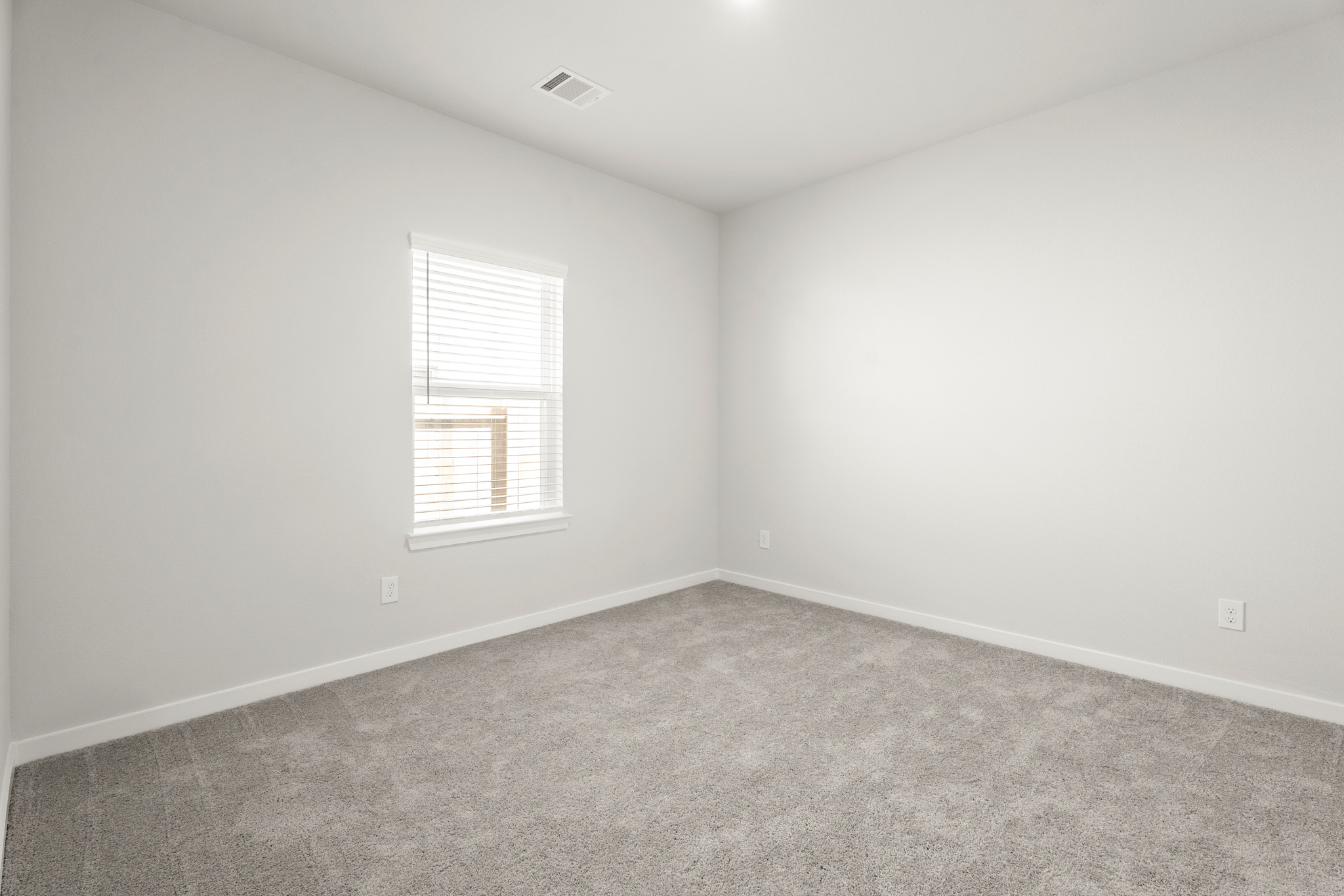 A room with a window and carpet.