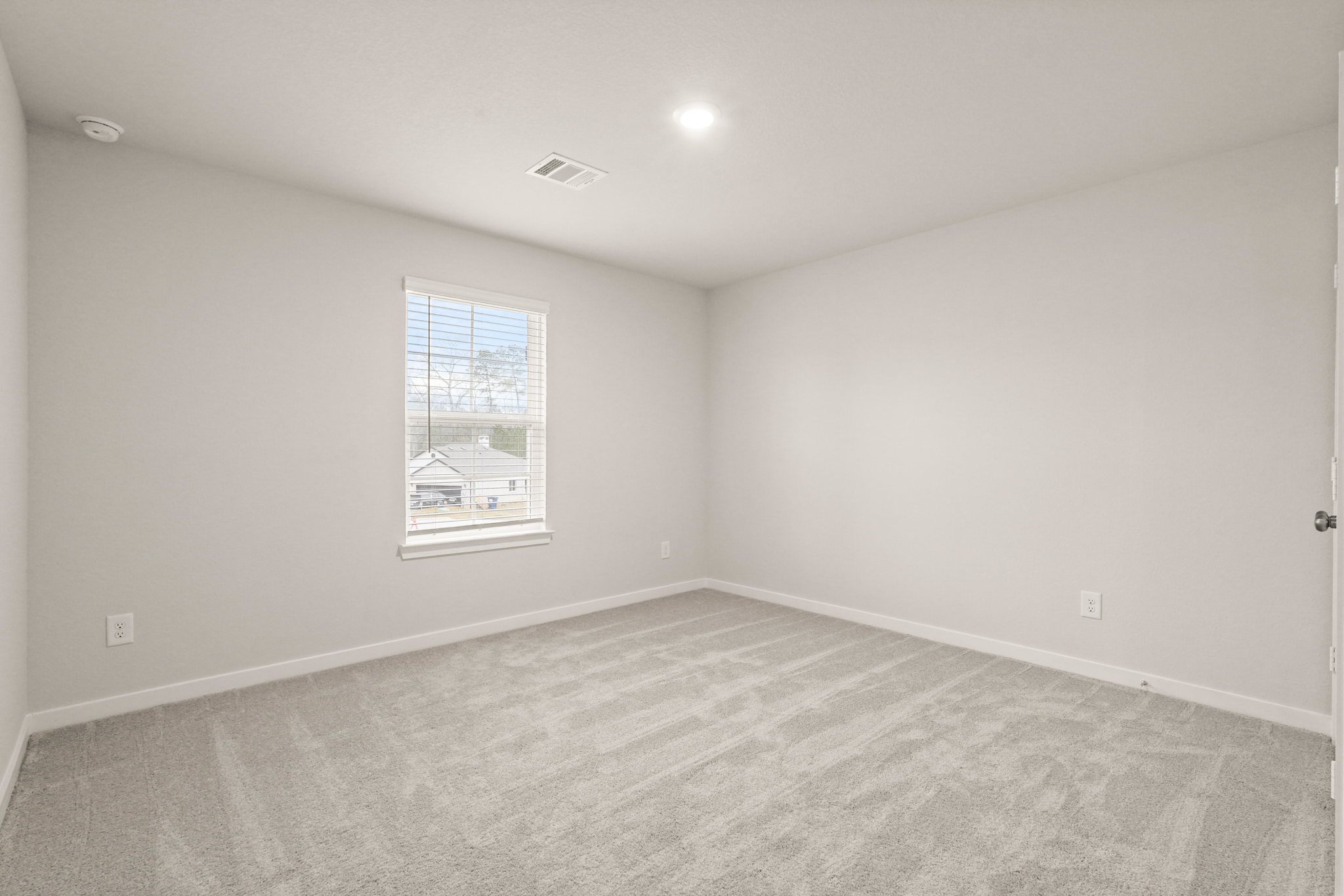 A room with a window and a carpet.