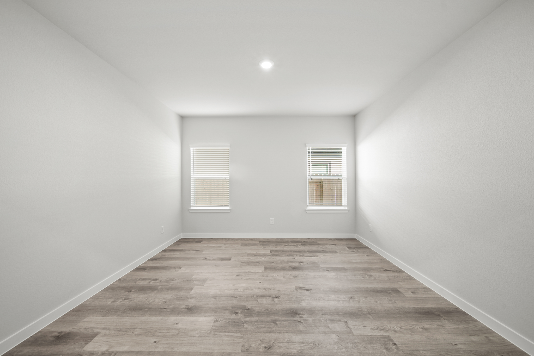 A room with a wood floor and white walls.