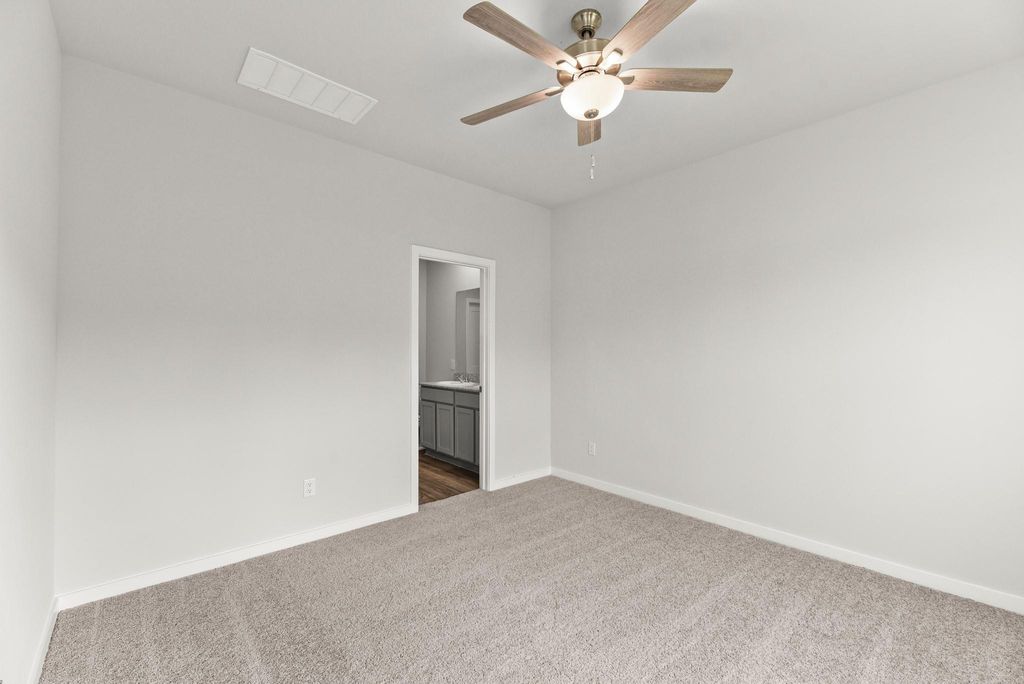 A room with a ceiling fan and a door.