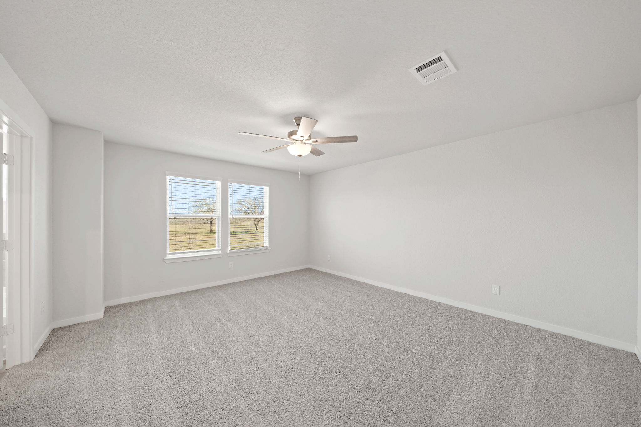 A room with a ceiling fan and a window.