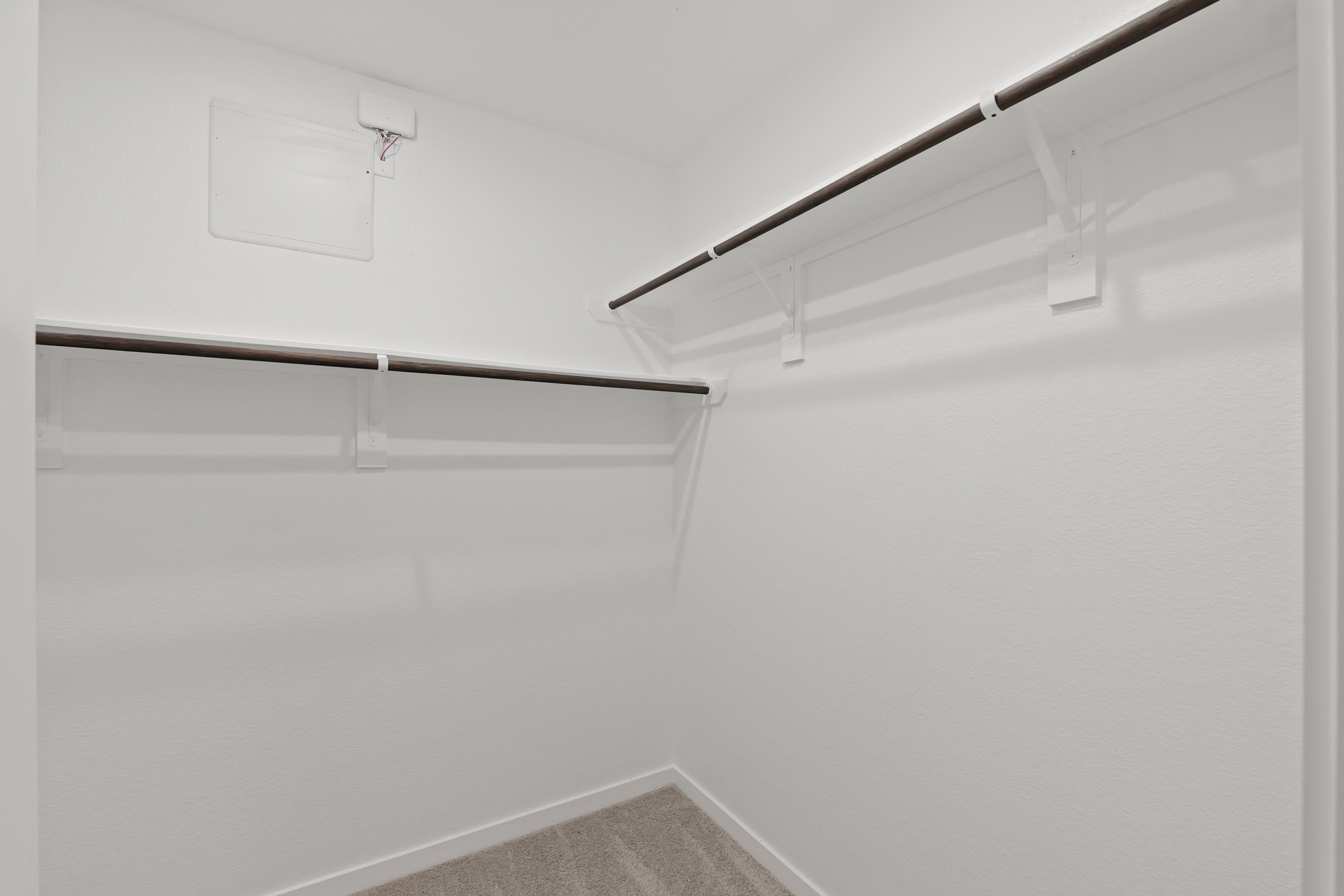 A white wall with a metal bar.