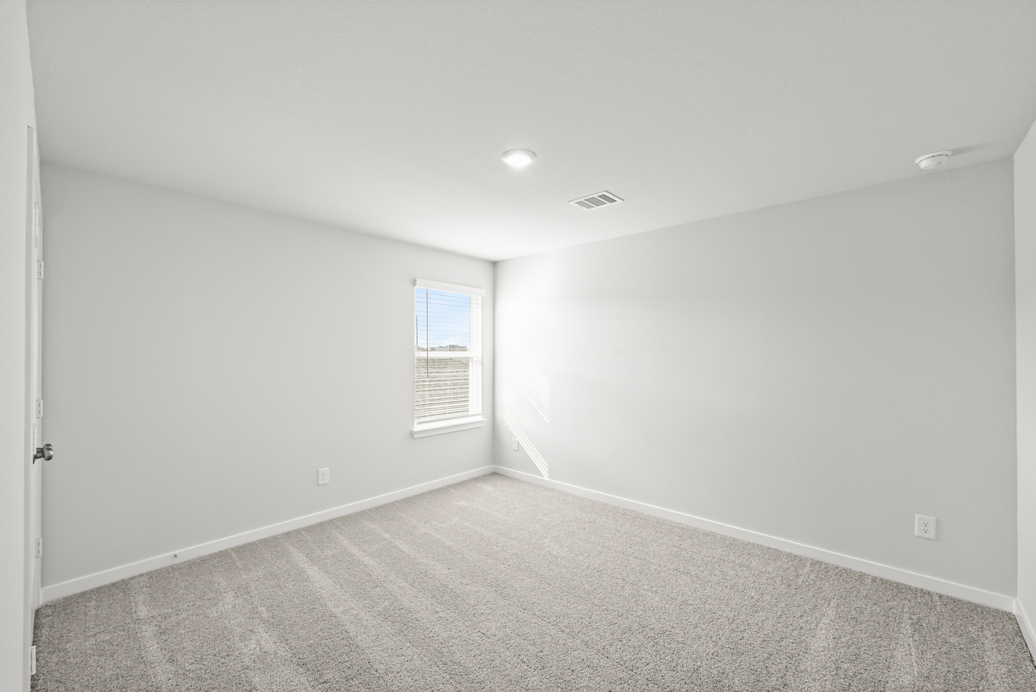 A room with a carpet and a window.