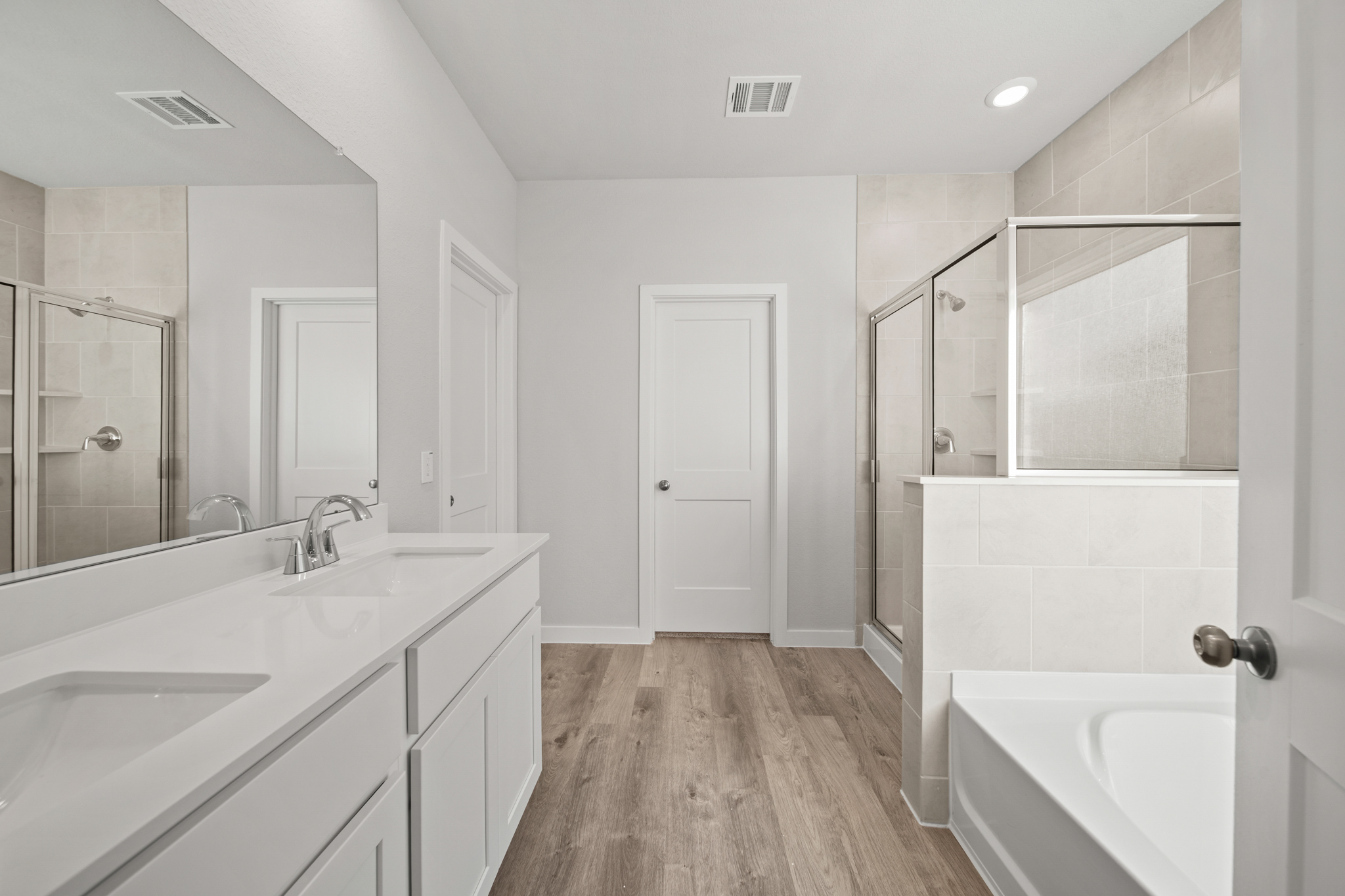 A bathroom with a tub sink and a mirror.