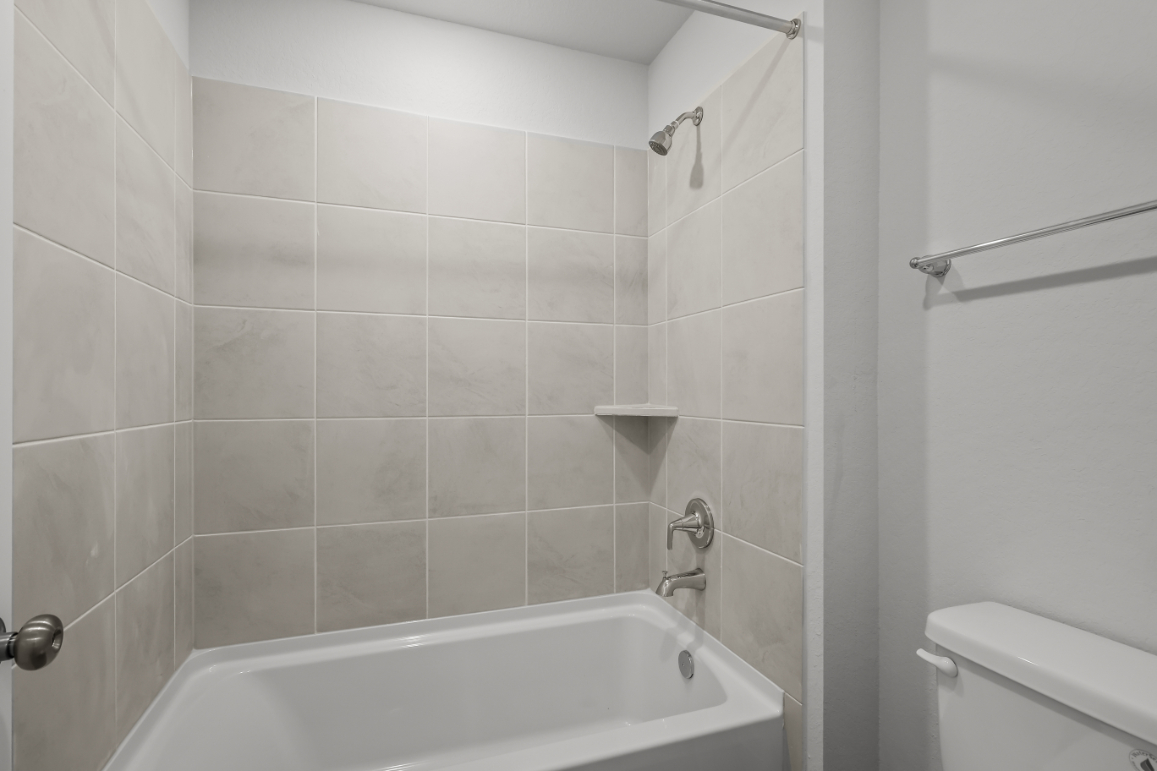 A bathroom with a bathtub and toilet.