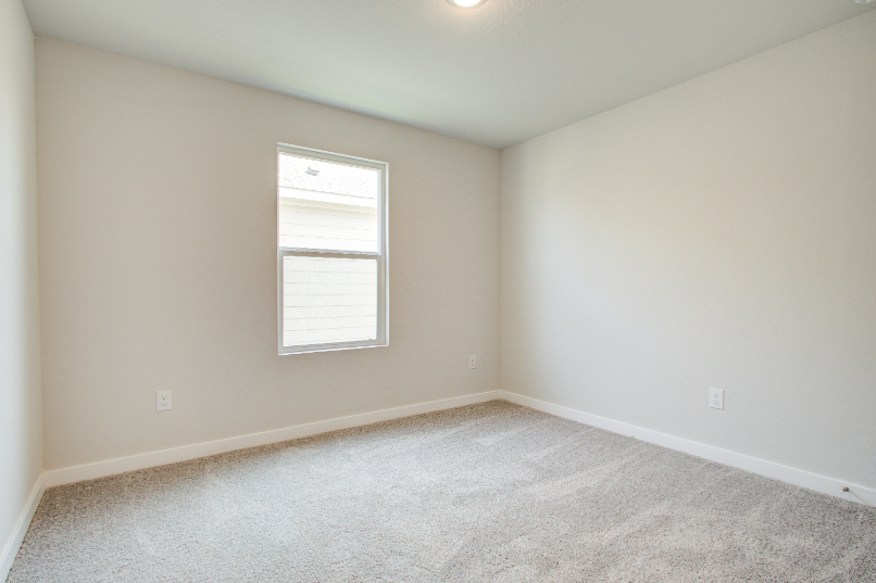 A room with a window and carpet.