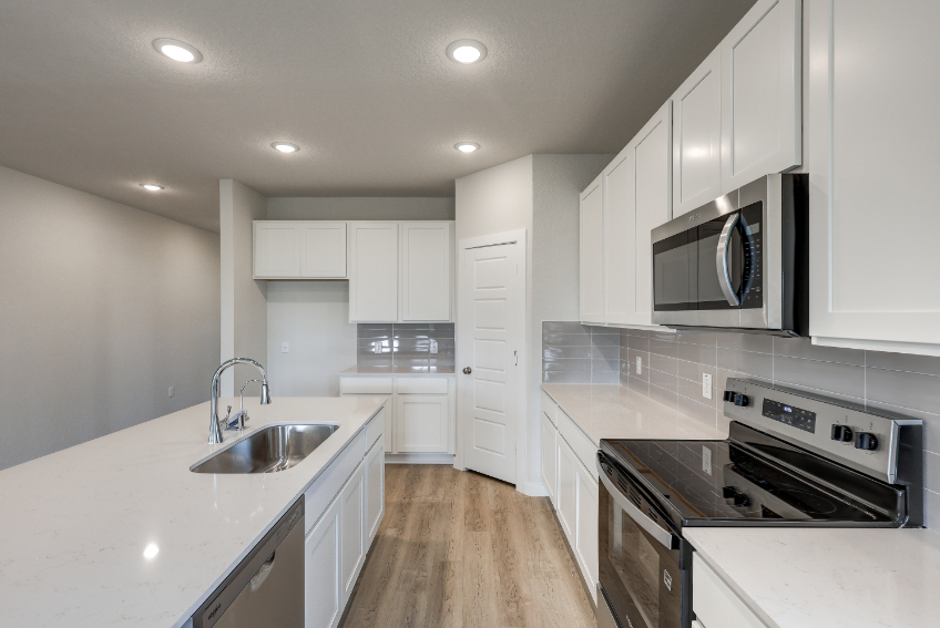 A kitchen with white cabinets.