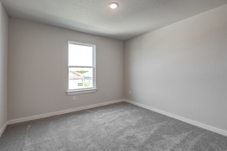 A room with a window and a carpet.