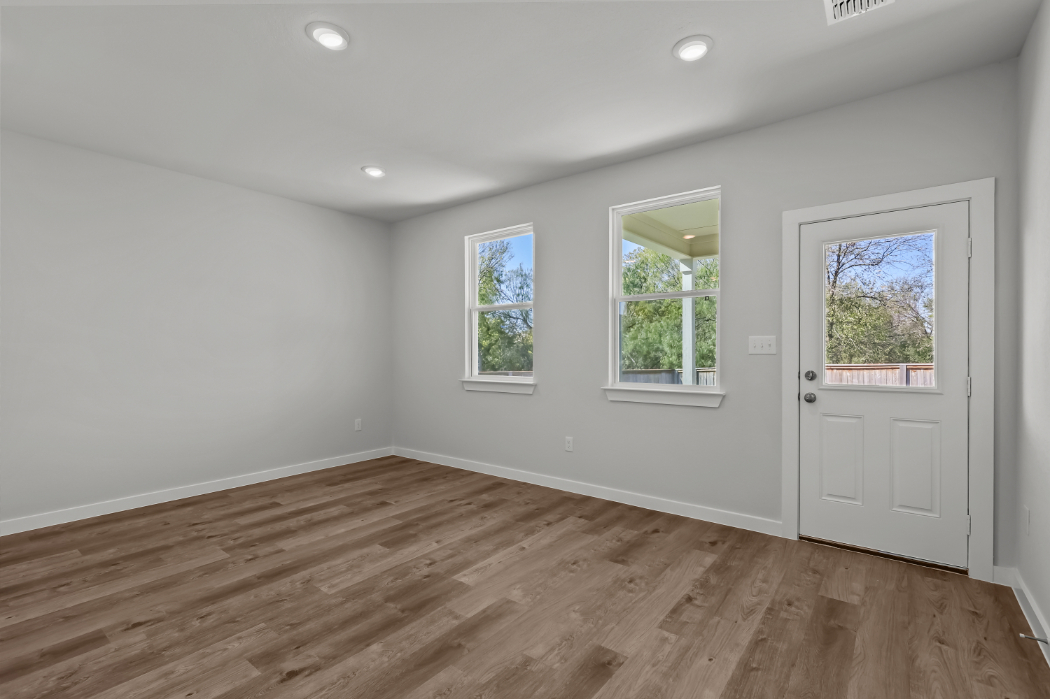 A room with a wood floor and windows.