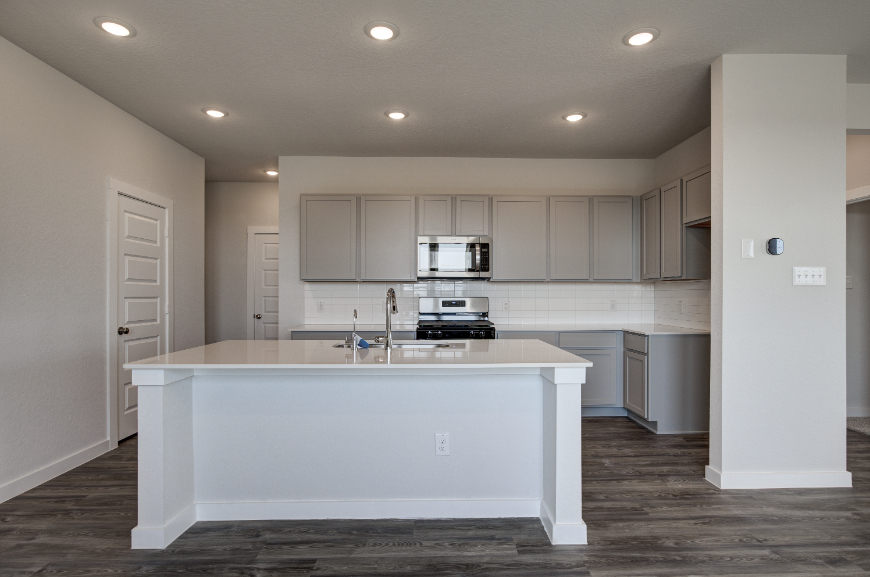 A kitchen with white cabinets.