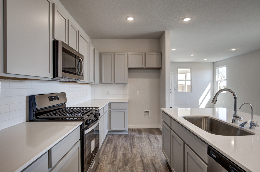A kitchen with white cabinets.