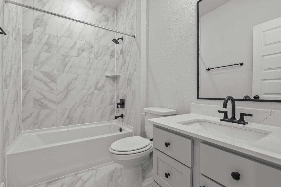 A bathroom with a tub sink and toilet.