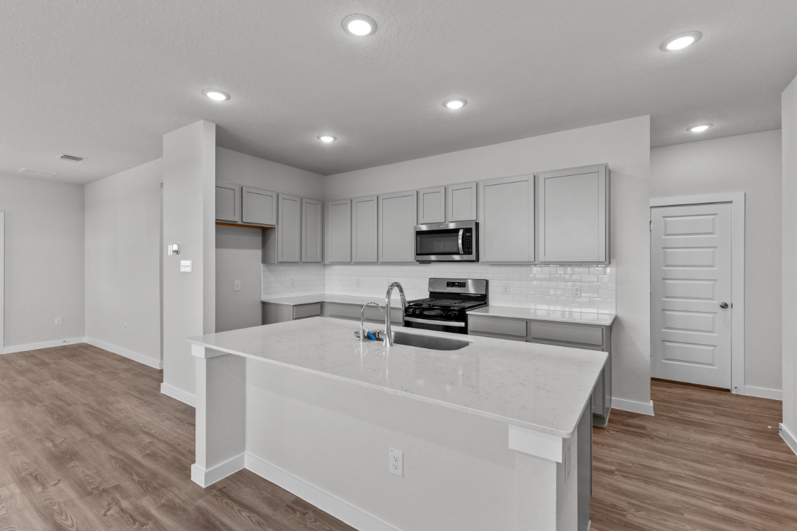 A kitchen with white cabinets.