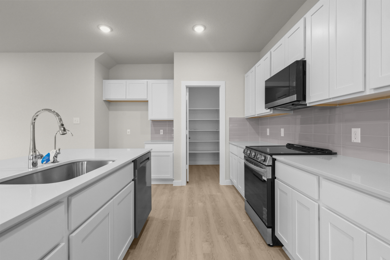 A kitchen with white cabinets.