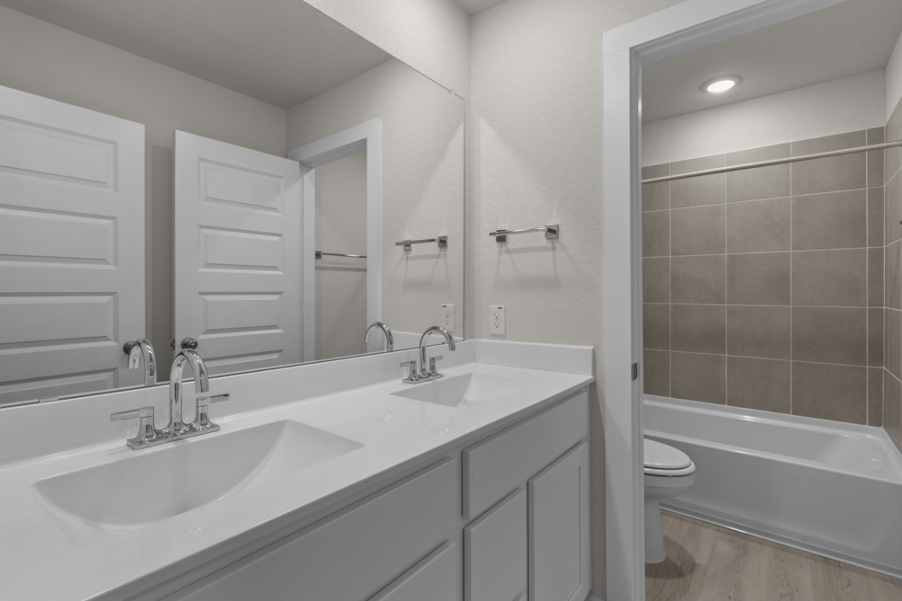 A bathroom with a tub sink and toilet.