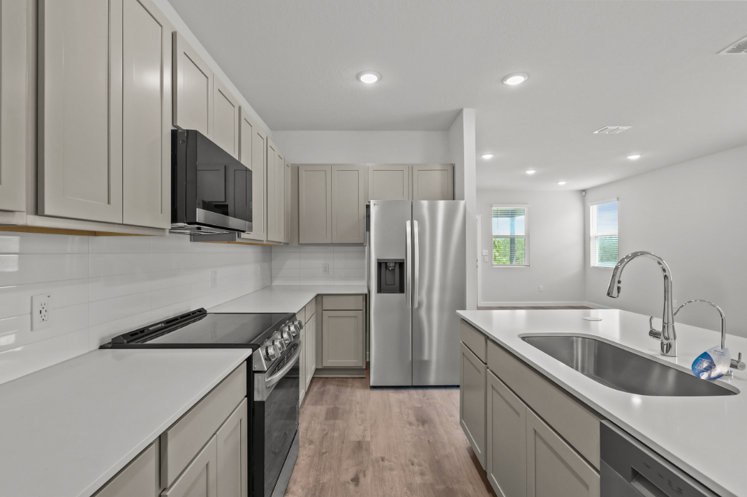A kitchen with white cabinets.