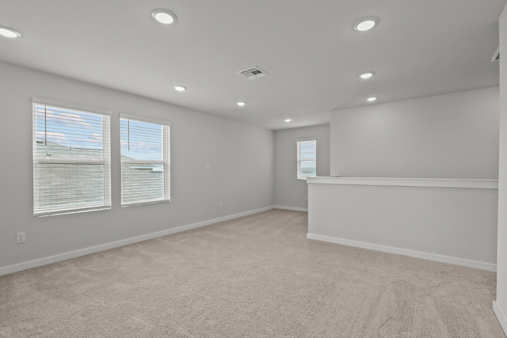 A room with a white wall and windows.